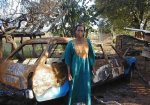 Evelyn Masaiti stands near her car burnt by ZANU PF thugs