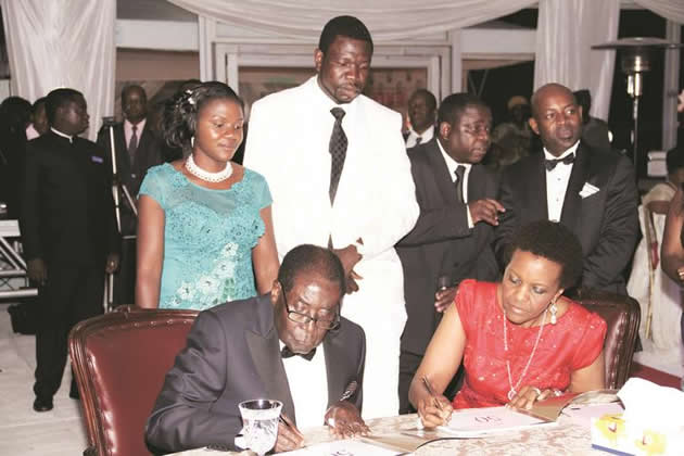 President Mugabe and First Lady Grace Mugabe sign the pictorial biography of the First Lady while Prophetic Healing and Deliverance Ministries leader Prophet Walter Magaya (second from left), his wife Tendai (left) and chairperson of the organising committee for the First Lady's birthday and fundraising dinner Mr Rodney Dangarembizi (extreme right) look on in Harare over the weekend
