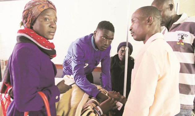 Distraught friends and relatives visited injured Dynamos fans admitted at Parirenyatwa Group of Hospitals in Harare yesterday. Here, midfielder King Nasama (in blue jacket) holds a phone for his mother Ms Shylet Tinonetsana in her bed. Ms Tinonetsana was among Dynamos fans who were involved in an accident near Battlefields about 20km outside Kadoma on Saturday. — (Picture by Tawanda Mudimu)