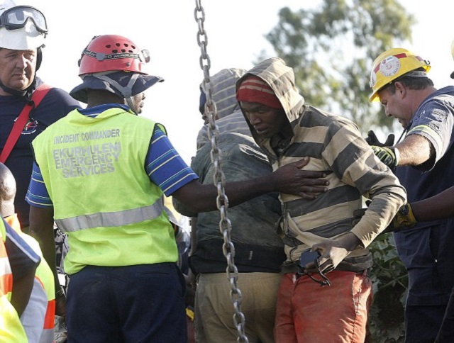 A suspected illegal miner with police and emergency workers at the mine in Benoni, east Johannesburg
