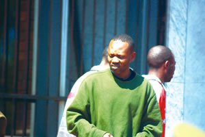 Gilbert Muponda being escorted by police