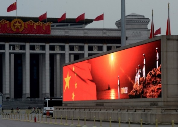 An image of the Chinese flag and sailors standing on the disputed Spratly Islands in the South China sea is displayed on a big screen in Tiananmen Square, March 2, 2013