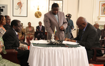 OLD GUARD: Finance Minister Patrick Chinamasa signs his letter of appointment as President Robert Mugabe looks on. Mr Chinamasa is largely credited for introducing the US dollar and the rand as the currencies of choice in his first short stint as finance minister in 2008-09. He was also the justice minister in the unity government. Picture: EVANS TADISWA