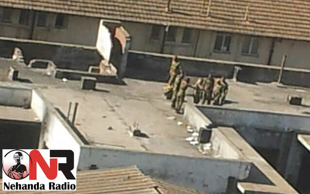 A Nehanda Radio Citizen Reporter captured these two pictures of a group of soldiers beating up civilians on top of a Harare building on the 20th of August 2013 at around 3:05pm