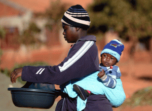 Woman carries baby on her back in this file photo