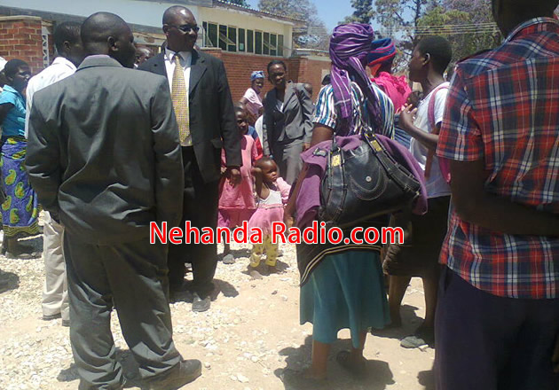 Disgruntled parents and their children mingle outside Mutoko magistrates’ court after the postponement of the case