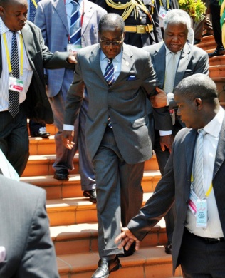 Ailing Mugabe about to fall and being aided by bodyguards.