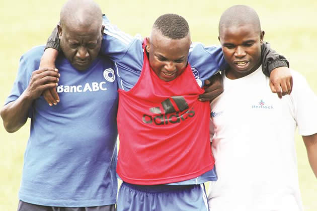 Dynamos new signing, Tafadzwa Rusike (centre), is helped off the training pitch by club vice-chairman, David Mandigora (left), who is aiding with the coaching duties, and physiotherapist Knowledge Zambo at Raylton in January this year