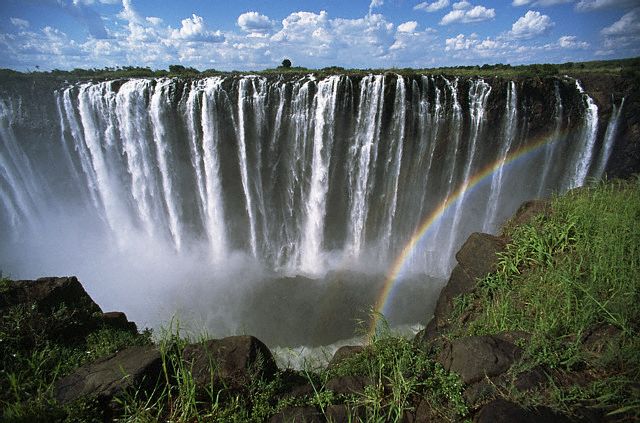 A rainbow forms as the turbulent waters of Zambezi River rush over Victoria Falls.