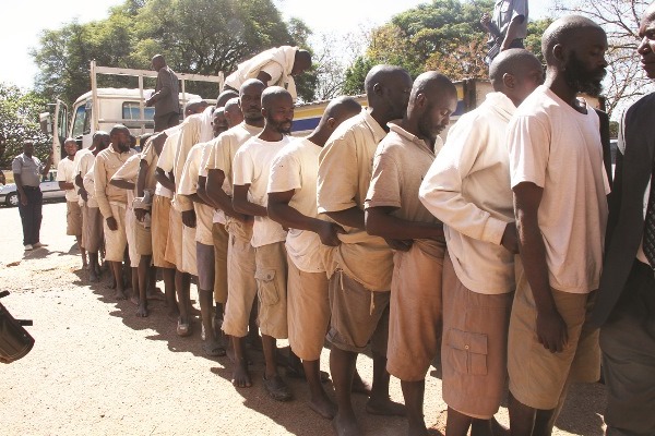 IN SINGLE FILE: Part of the group of 24 Vapositori are escorted by anti-riot police and detectives into the Harare Magistrates' Courts. Pic: Annie Mpalume (Daily News)