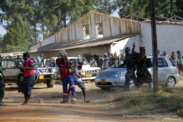 Fungai Dhlakama (red top) one of Samson Chauruka’s supporters fights one of the ex-farm workers on Monday while others join in. (Picture by NewsDay)
