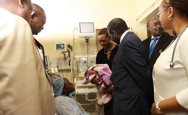 President Mugabe and First Lady Amai Grace Mugabe have a look on one of the once cojoined twins seperated during an operation while the mother Agnes Chitiyo looks on with other officials.-(picture by Munyaradzi Chamalimba)