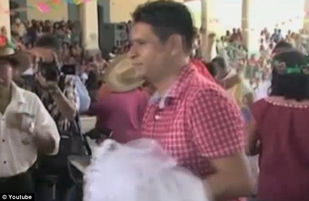Snapped up: Mexican town mayor Joel Vasquez Rojas 'married' a crocodile dressed in a white gown yesterday, in a symbolic ceremony that's part of a local tradition