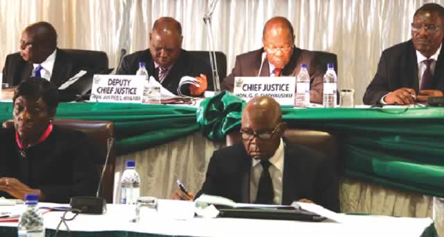 Judicial Service Commission members, Chief Justice Godfrey Chidyausiku flanked by Deputy Chief Justice Luke Malaba and Judge President George Chiweshe and Chief Magistrate Mishrod Guvamombe (left) and below Justice Rita Makarau and Human Rights consultant Richard Makoni, follow proceedings during interviews for aspiring Supreme Court judges in Harare