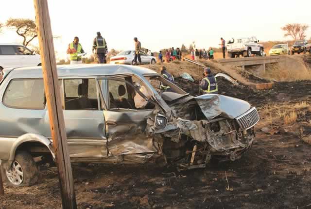 Police and onlookers at the scene of the crash along the Plumtree-Bulawayo highway yesterday