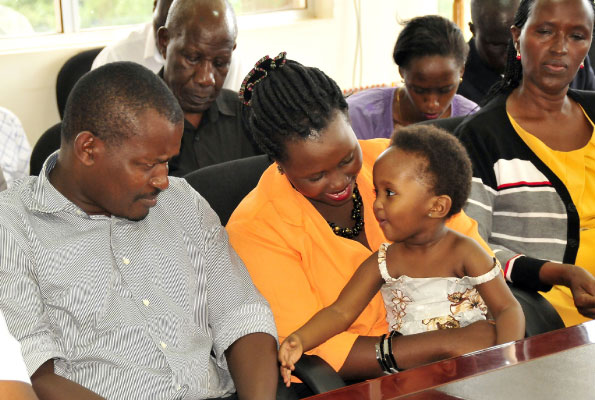 Mr Eric Kamanzi shares a light moment with his daughter Arnella Kamanzi together with her mother Angela Mbabazi at the police headquarters in Kampala yesterday. Photo by Michael Kakumirizi
