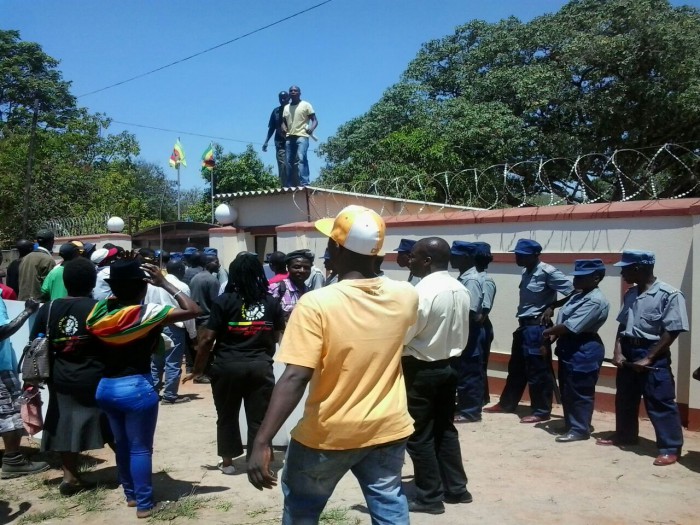 Some youths climb on top of the guardroom at the party headquarters in an attempt to gain entrance. Pic by Farirai Machivenyika
