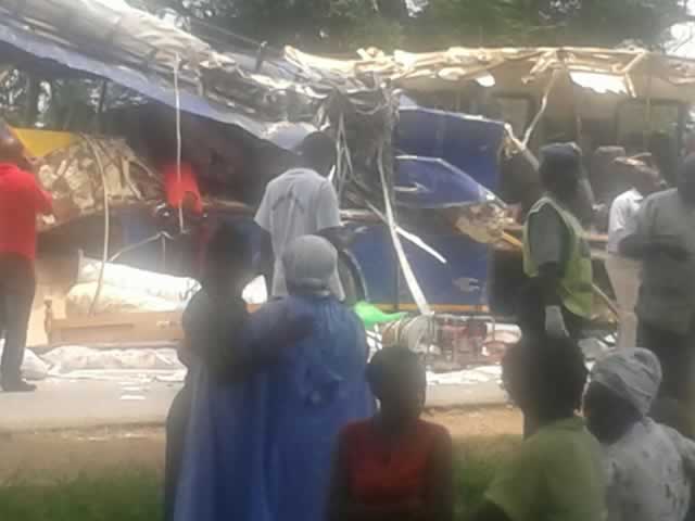 Onlookers gather around the scene of the accident where more than 20 people are feared dead