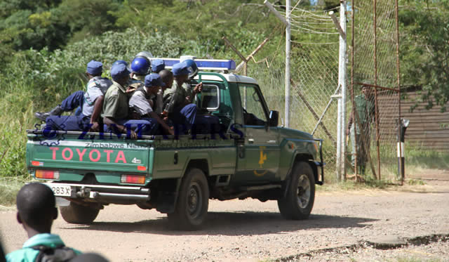 Members of the Police Support Unit drive into Chikurubi Maximum Security Prison to quell a food protest by prisoners