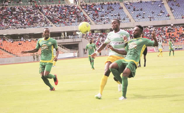 C Platinum striker Obrey Chirwa (centre) fights for the ball with Sherman Kpah (right) while another Young Africans defender Kelvin Yondani closes in during yesterday’s CAF Confederations Cup first round, first leg match in Dar es Salaam. — (Picture by Paul Mundandi)