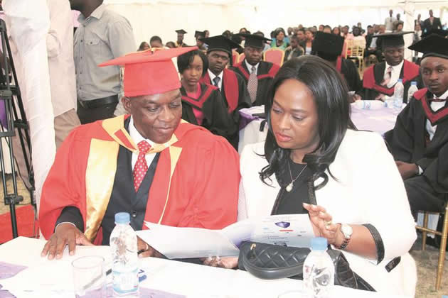 Police Commissioner-General Augustine Chihuri goes through the programme with his wife Isabel Chihuri after graduating with a Doctor of Philosophy Degree at Mt Camel Institute of Business Intelligence in Harare on Saturday