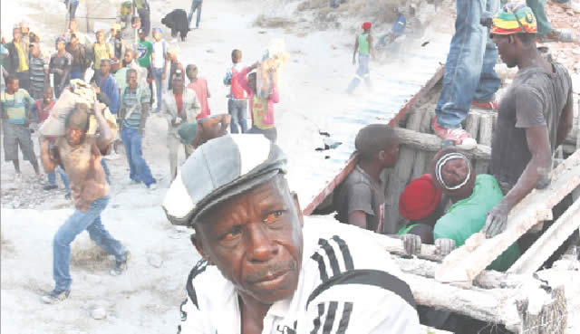 Malachi Sigogo (in cap) explains the tragedy while illegal miners carry sacks of gold ore away from the mine in West Nicholson yesterday (Picture by The Chronicle)