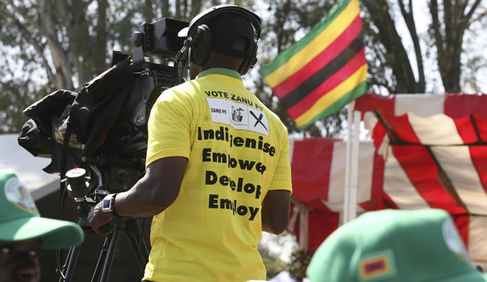 A ZBC cameraman wears a ZANU-PF t-shirt as he covers the President Robert Mugabe's election campaign and manifesto launch at Zimbabwe Grounds in Harare