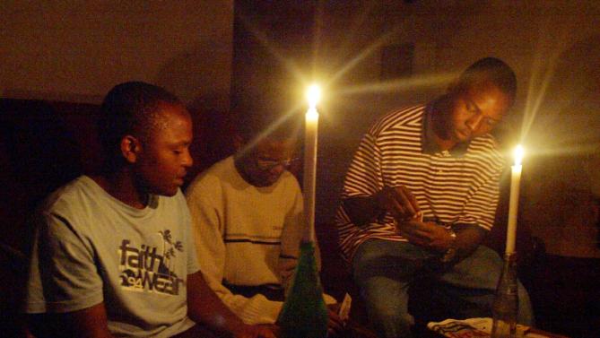 A Zimbabwean family plays cards in Harare after a power cut