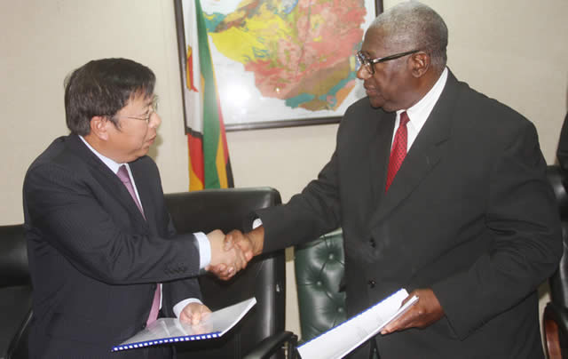 ZMDC board chairman Mr David Murangari (right) and Beijing Pingchang Investments chief representative in Zimbabwe Shouming Lin shake hands after the signing of the Kamativi Tin Mine deal yesterday. — (Picture by Munyaradzi Chamalimba)