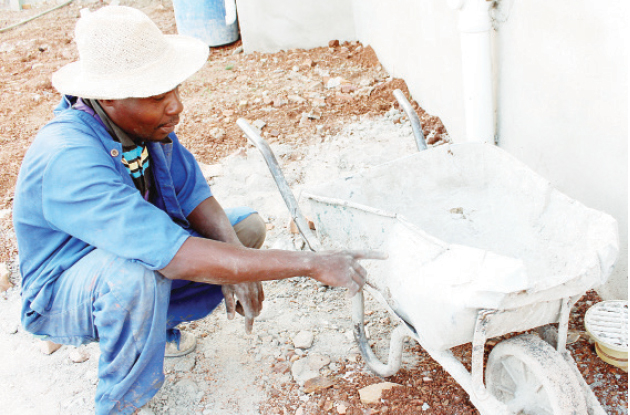 A builder, Zibonele Gwetshwayo, shows one of the wheelbarrows that rivals damaged during an attack in Mahatshula suburb, Bulawayo yesterday (Picture by The Chronicle)