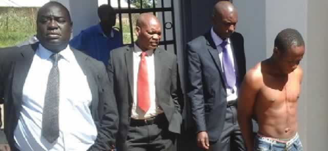 Homicide detectives escort Jackson Moyo at the Mvuma police station in this file photo