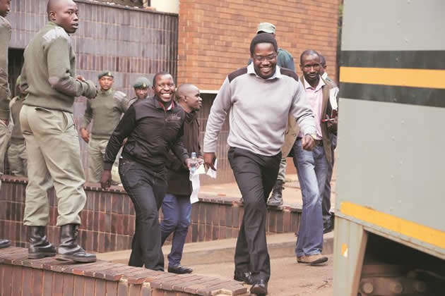 Sunday Mail editor Mabasa Sasa, reporters Brian Chitemba (in brown jacket) and Tinashe Farawo are all smiles after being freed on bail at the Harare Magistrates’ Court yesterday.