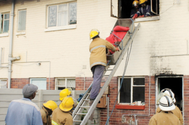 Police and a firefighting crew at the Lundi Park apartment where three family members died in a fire (Picture by The Chronicle)