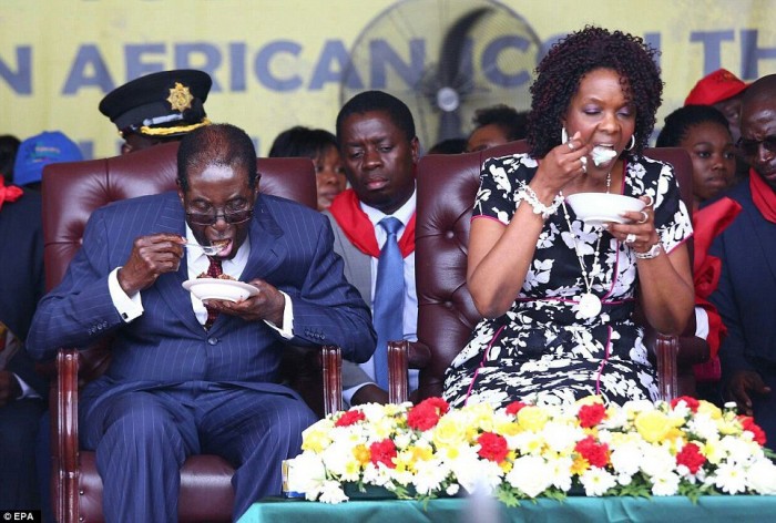 Feast for two: Zimbabwean President Robert Mugabe pictured with his wife Grace eating at his 92nd birthday party on Saturday.