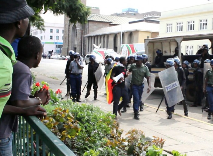 Face to Face: Dr Patson Dzamara comes face to face with riot police in Harare during a march protesting the abduction of his brother Itai Dzamara