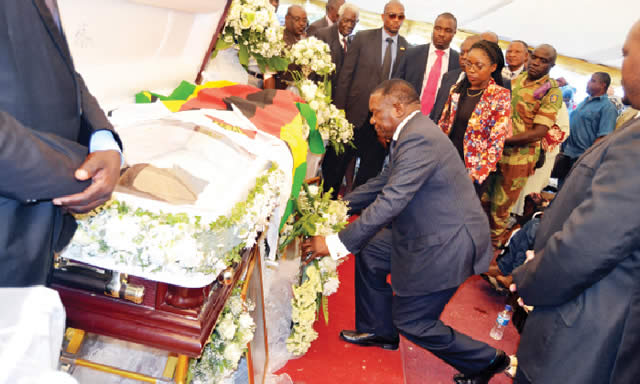 Vice President Emmerson Mnangagwa lays a wreath on the late Dr Samuel Mumbengegwi’s coffin at his rural home in Chivi yesterday