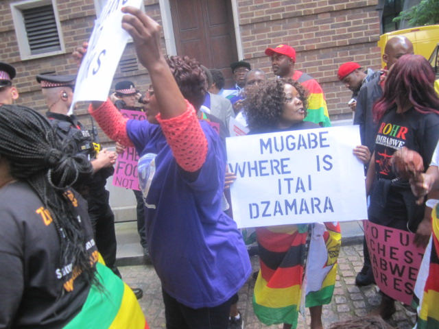 Zimbabwean demonstrators lay down in the road outside the conference in London addressed by Zimbabwe’s Finance Minister Patrick Chinamasa preventing him from leaving for more than an hour.