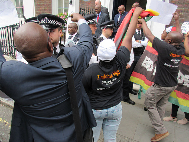 Zimbabwean Finance Minister Patrick Chinamasa was besieged in London by angry Zimbabwean exiles and had to be rescued by a vanload of police.