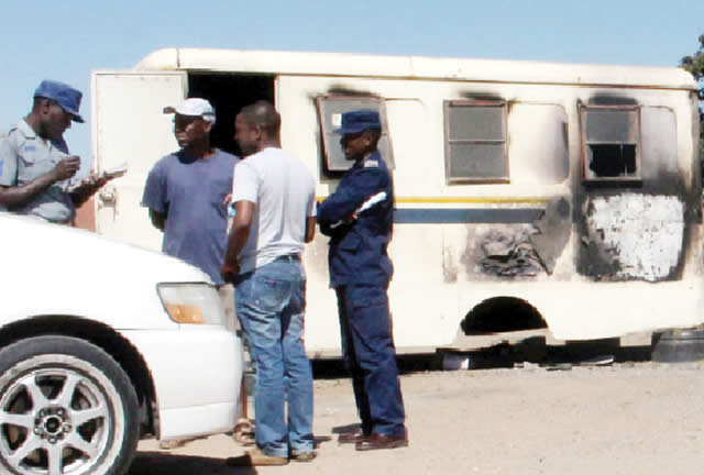 Police officers take notes at the police base which caught fire in Emakhandeni, Bulawayo, yesterday