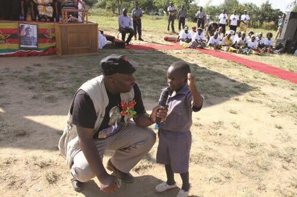 There is growing outrage over a picture showing Local Government minister, Saviour Kasukuwere, forcing a child to execute a Zanu PF slogan.