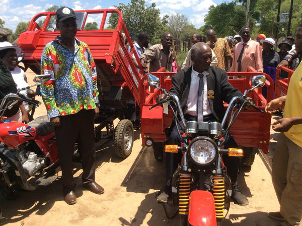 Jonathan Moyo dishing out motorbikes for headman and bicycles for village heads in Tsholotsho