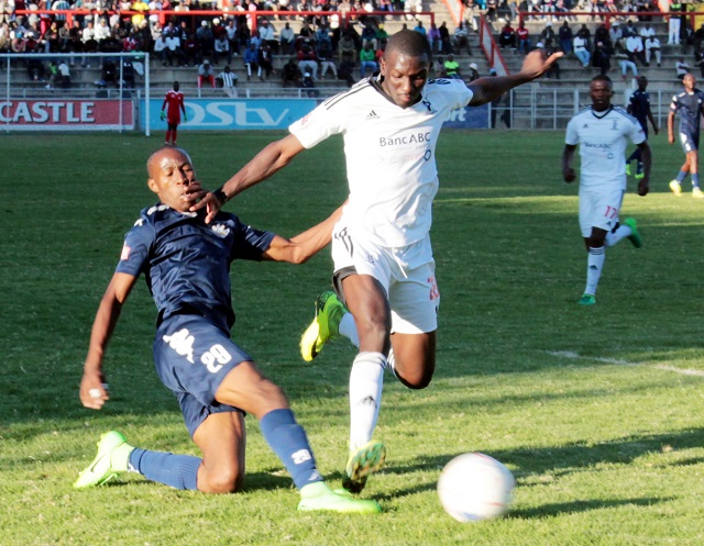 Highlanders defender Benson Phiri (right) blocks How Mine’s striker Toto banda from getting the ball in yesterday’s Castle Lager Premier Soccer League match at Barbourfields Stadium yesterday. (Picture by Almost Almond Mthembo)