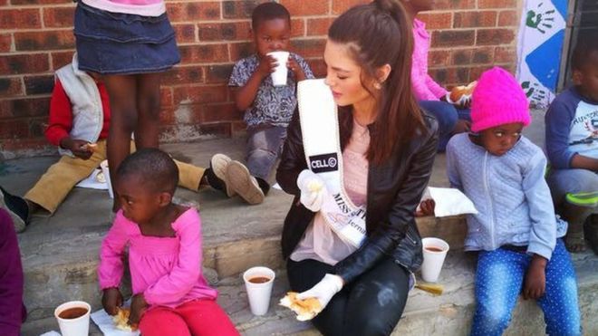 Photos of Miss South Africa wearing gloves while visiting black children at an orphanage in Soweto sparked a online outcry - but the orphanage staff say any insinuation that Demi-Leigh Nel-Peters is racist is "ridiculous".