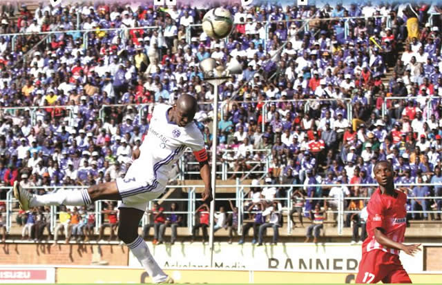 Dynamos skipper Ocean Mushure goes airborne to connect with a cross from Christian Epoupa, while Yadah defender Willard Kalongonda watches anxiously during yesterday’s match at Rufaro. — (Picture by Kudakwashe Hunda)
