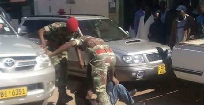 Soldiers seen here beating up an unidentified man
