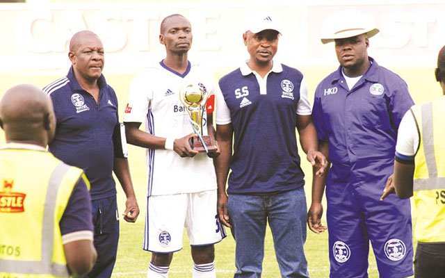 Dynamos captain Ocean Mushure (second from left) is presented with his award for being the fans’ Player of the Month and poses for a picture flanked by his team manager Richard Chihoro (left) and vice-president Solomon Sanyamandwe (second from right) at Rufaro