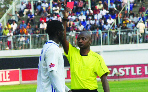 FROM HERO TO ZERO…..Dynamos goal scorer Christian Epoupa Ntouba (left) walks off the pitch as referee Arnold Ncube brandishes a red card to him for head butting Highlanders player Peter Muduhwa in a goal mouth melee during the closing stages of yesterday’s Premiership soccer match at Rufaro.-Picture by Memory Mangobe