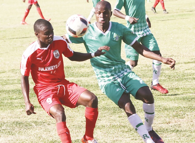 Bulawayo City striker Clive Rupiya tussles for possession with Caps United defender Stephen Makatuka at Hartsfield Ground