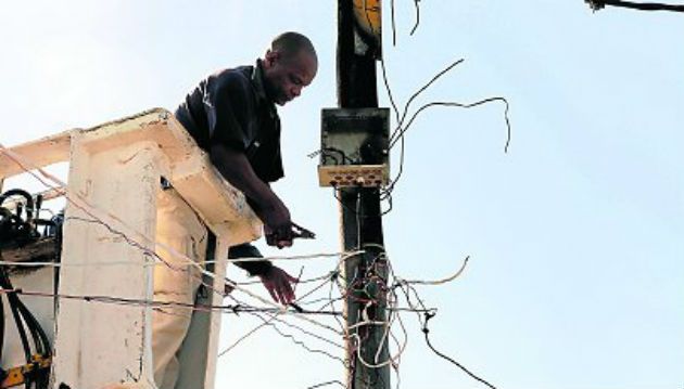 A municipal worker removes dangerous illegal electricity connections in South Africa