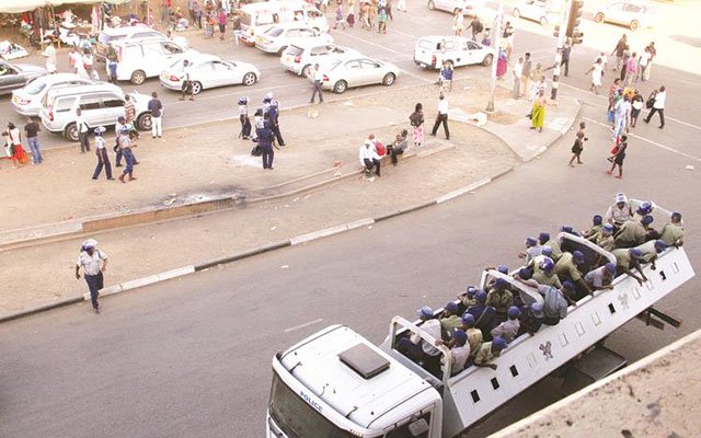 Police officers enforcing the ban on illegal vendors along Simon Muzenda Street (formerly Fourth Street) in Harare yesterday afternoon